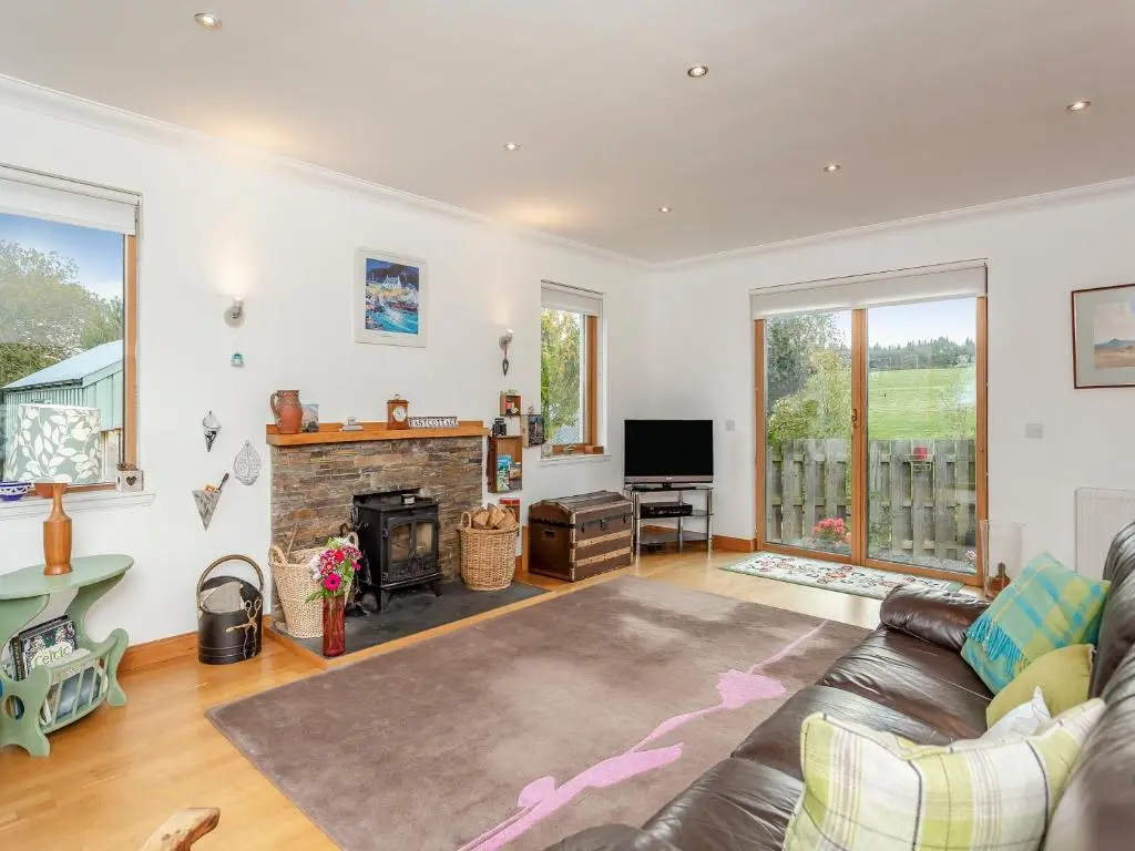 a living room with a couch and a fireplace at East Cottage in Cawdor