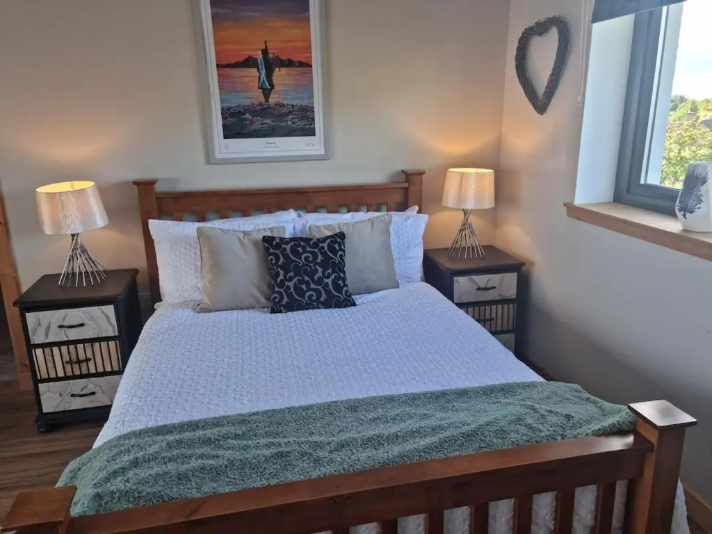 a bedroom with a large bed with two night stands at Village view apartment in Auldearn