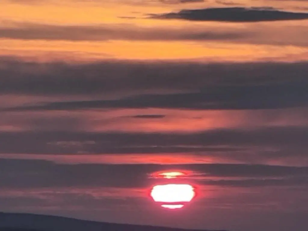 a sunset with the sun in the sky at Village view apartment in Auldearn