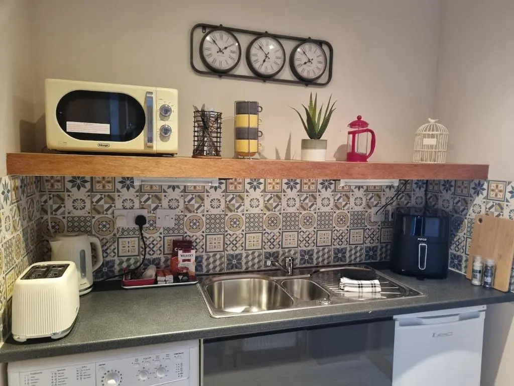 a kitchen counter with a sink and a microwave at Village view apartment in Auldearn