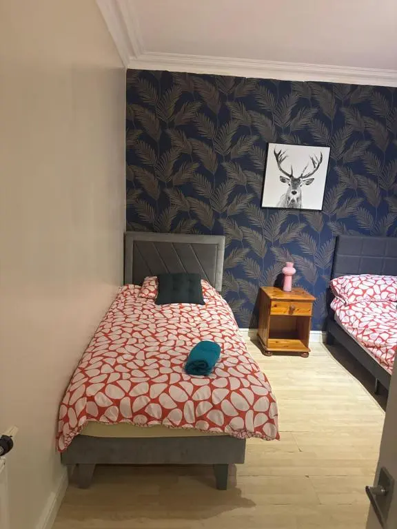 a bedroom with two twin beds and a table at Georges 47 king street Apartment in Inverness