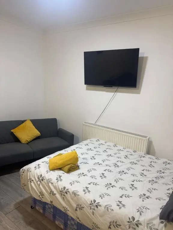 a room with a bed and a couch and a flat screen tv at Georges 47 king street Apartment in Inverness