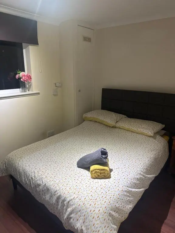 a bedroom with a bed with a yellow towel on it at Georges 47 king street Apartment in Inverness