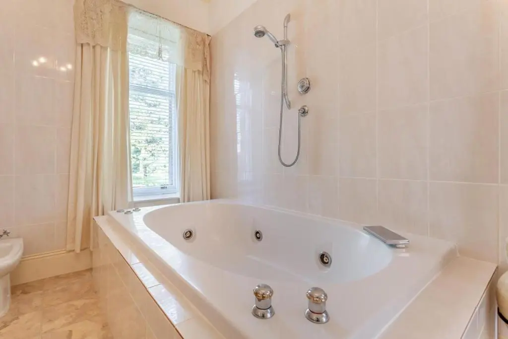 a white bath tub in a bathroom with a shower at 8 Bed in Invergordon oc-p32711 in Invergordon