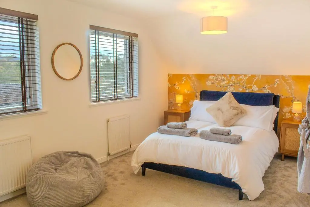 a bedroom with a bed with towels on it at 18 Dalfaber Park- with hot tub in Aviemore in Aviemore