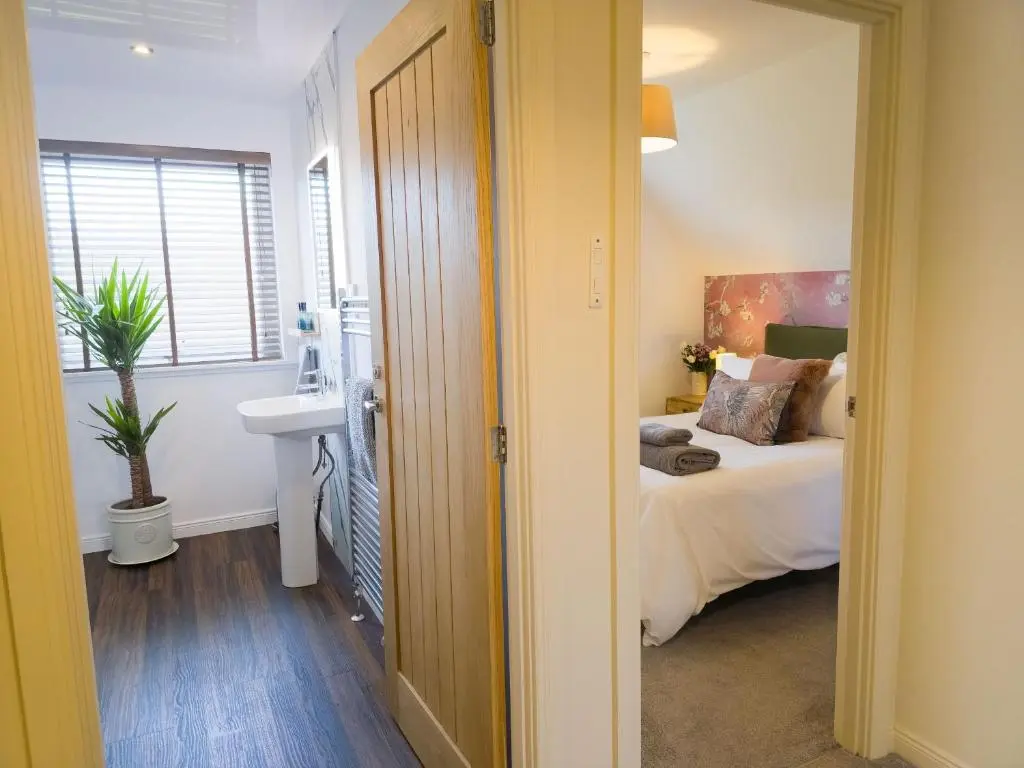 a bedroom with a bed and a sink in a room at 18 Dalfaber Park- with hot tub in Aviemore in Aviemore