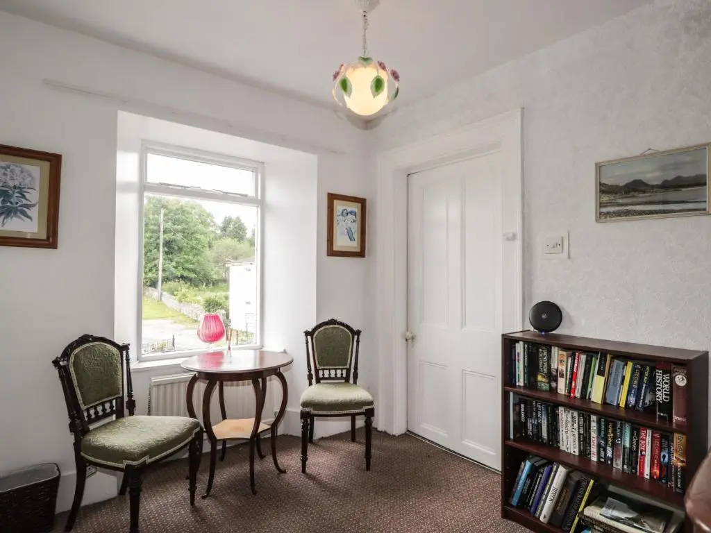 a living room with a table and chairs and a window at Ivy House in Kingussie
