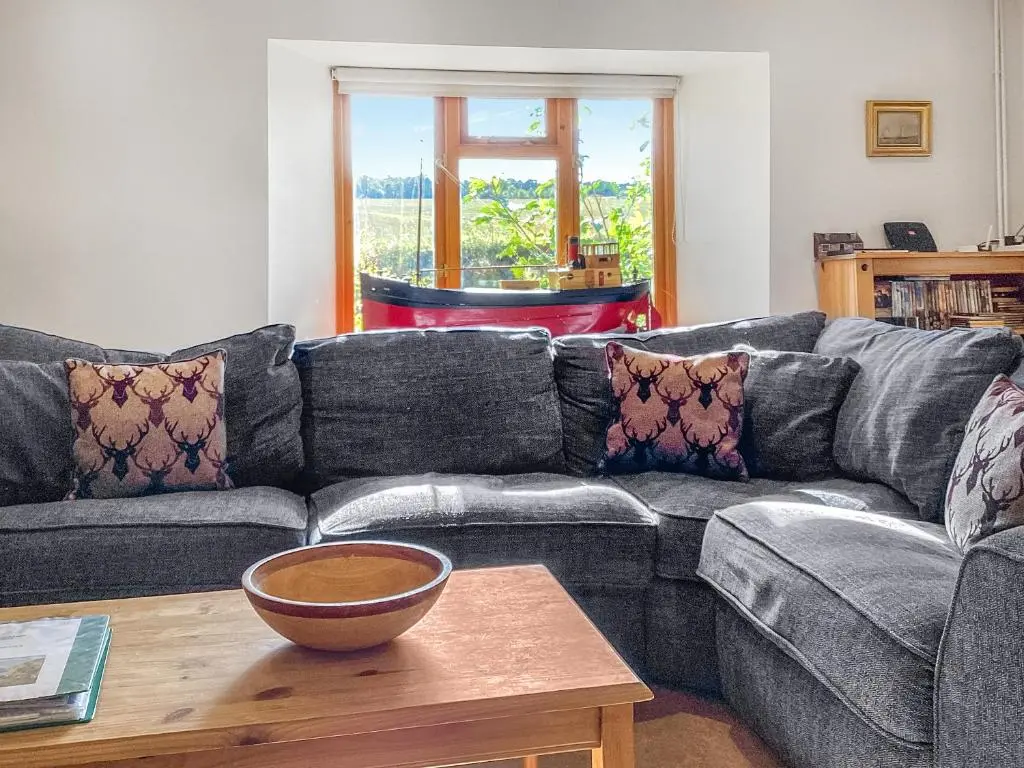 a living room with a couch and a table at Old Laurel Cottage in Jemimaville