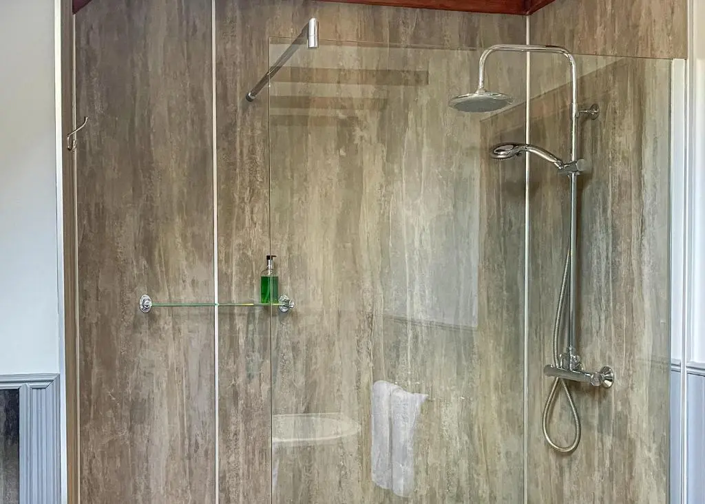 a shower with a glass door in a bathroom at Glen Clova Lodges in Angus