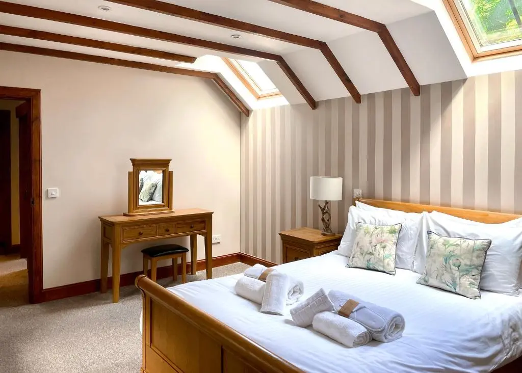 a bedroom with a bed with towels on it at Glen Clova Lodges in Angus