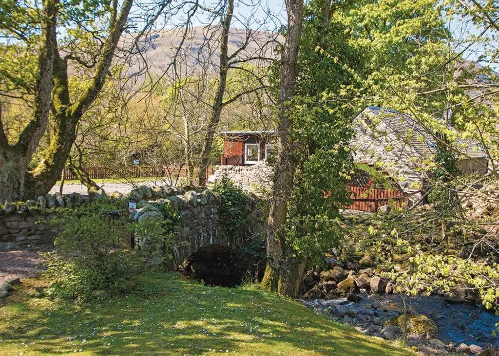 a house in the middle of a yard with trees at Glen Clova Lodges in Angus