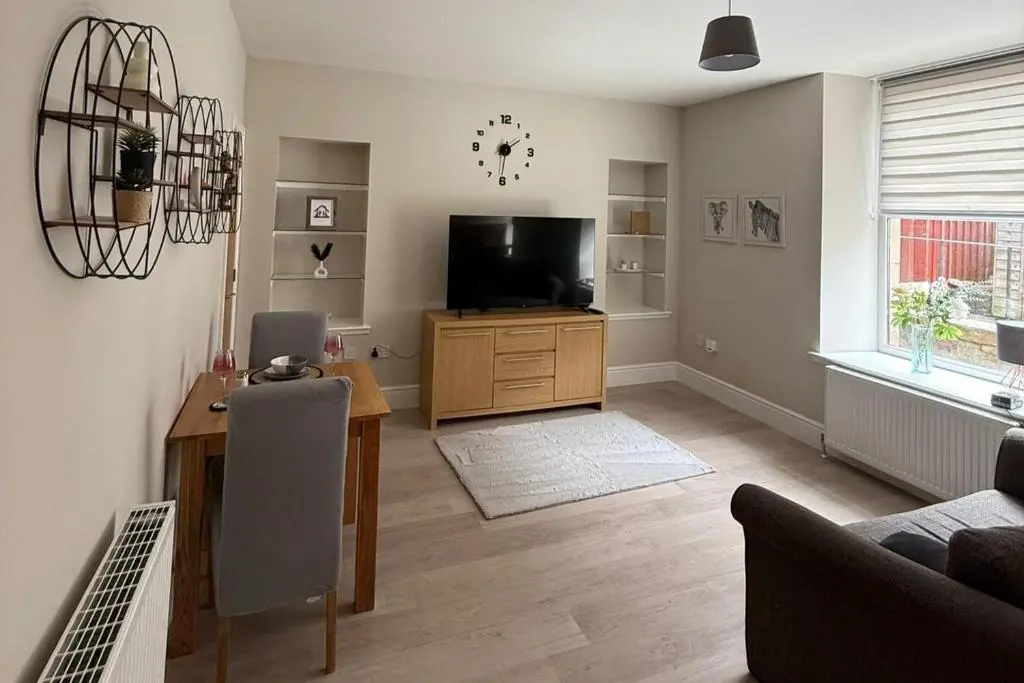 a living room with a television and a table at 1 Bed Flat - Sleeps 2 - Parking - Wifi in Nairn