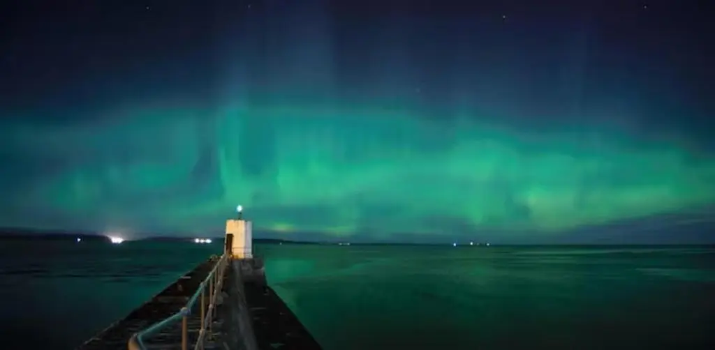 a lighthouse on a pier in the water at night at 1 Bed Flat - Sleeps 2 - Parking - Wifi in Nairn