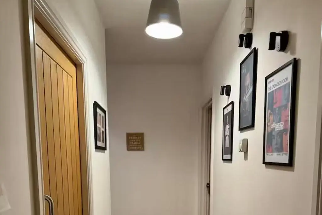 a hallway with a door and pictures on the wall at 1 Bed Flat - Sleeps 2 - Parking - Wifi in Nairn