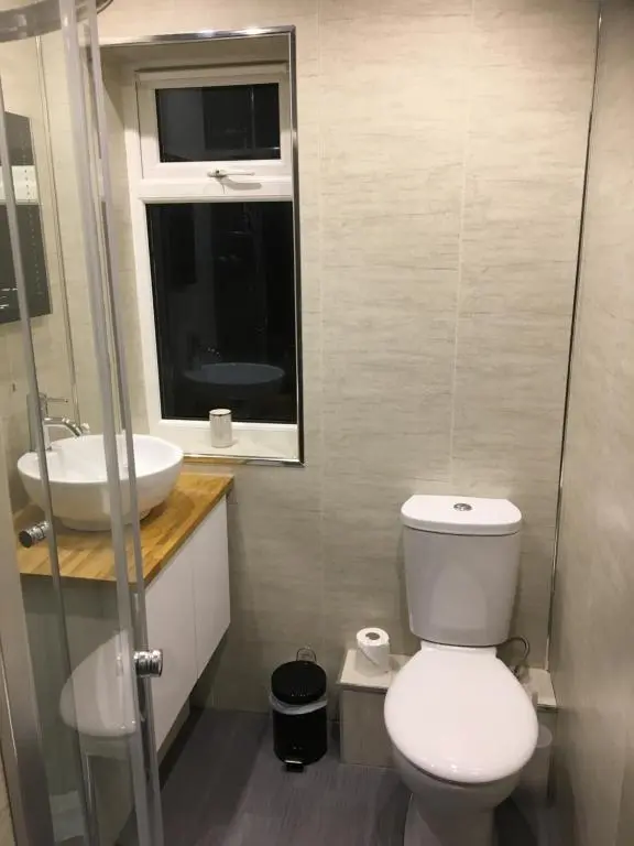 a bathroom with a toilet and a sink at Treetops Bungalow Loch Ness in Drumnadrochit