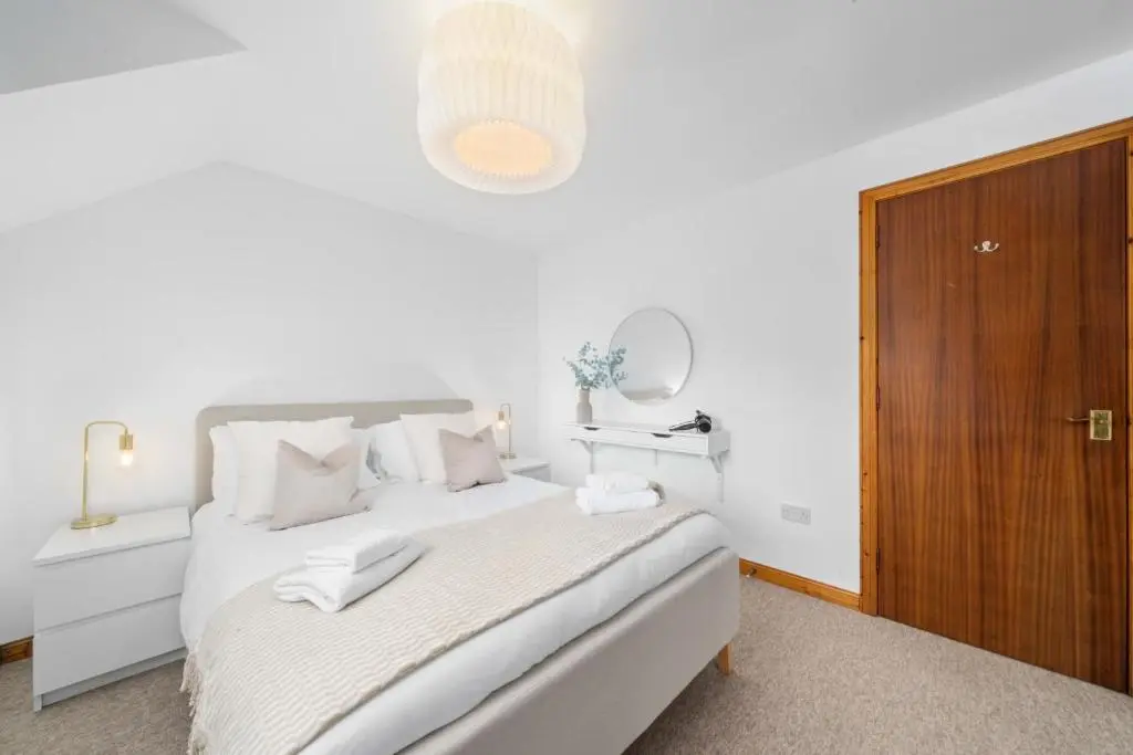a white bedroom with a large bed and a mirror at King Cosy 2 Bedroom Apartment - Inverness in Inverness