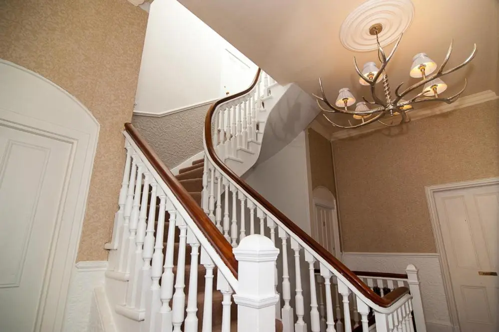 a staircase with a chandelier in a house at The Penthouse Self Catering in Nairn