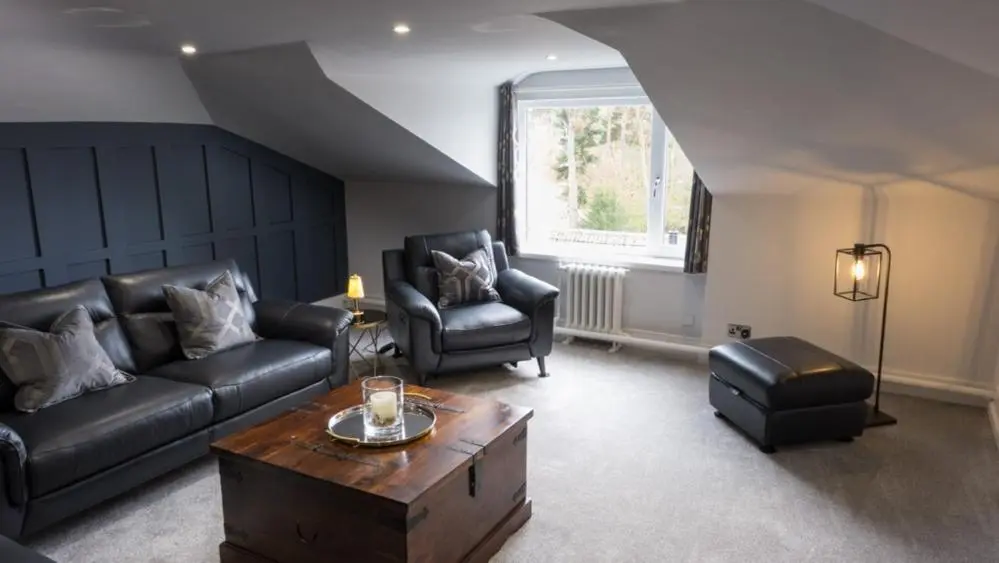 a living room with a couch and chairs and a table at The Penthouse Self Catering in Nairn