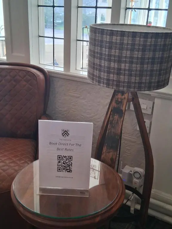 a lamp with a sign on a table next to a chair at The Penthouse Self Catering in Nairn