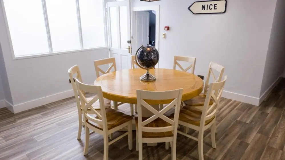 a dining room table with chairs and a vase on it at The Penthouse Self Catering in Nairn