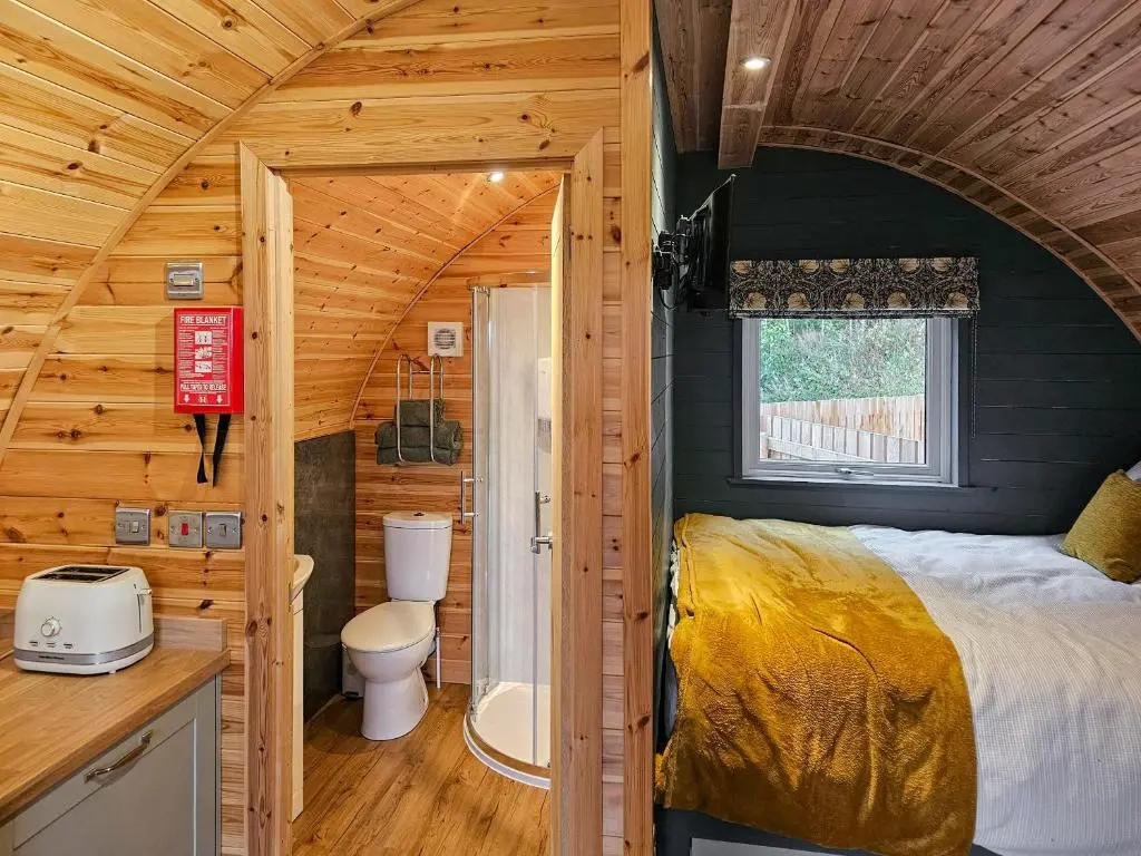 a bedroom in a log cabin with a bed and a toilet at Gallowhill Kirkside - Uk46515 in Newmill