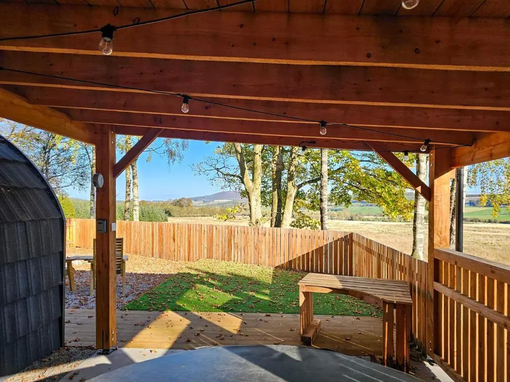 a wooden pavilion with a wooden bench in a yard at Gallowhill Kirkside - Uk46515 in Newmill