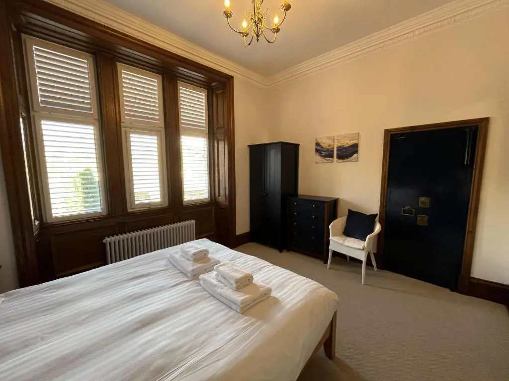 a bedroom with a bed with two towels on it at Bank House apartment in Fort Augustus