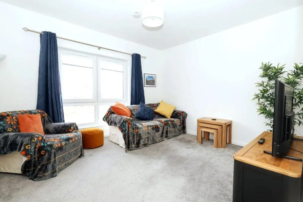 a living room with a couch and a tv at Inverness Haven: Bright 2B/2B with Scenic Views in Inverness