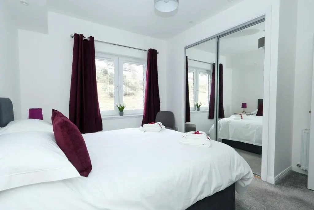 a bedroom with two white beds and a mirror at Inverness Haven: Bright 2B/2B with Scenic Views in Inverness