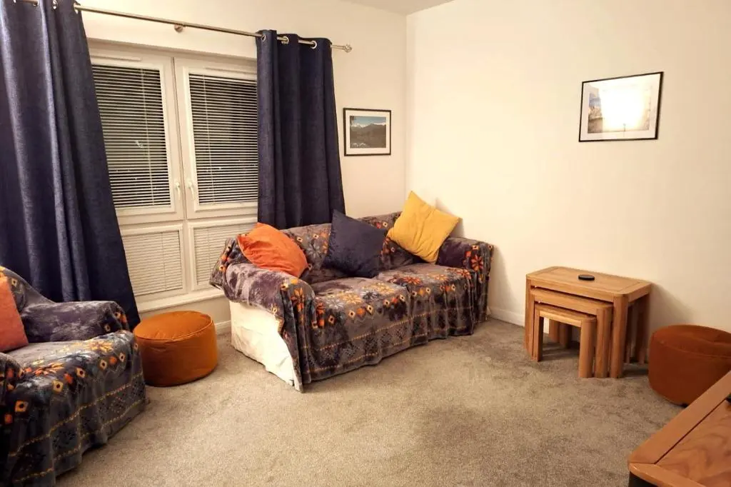 a living room with a couch and a table at Inverness Haven: Bright 2B/2B with Scenic Views in Inverness