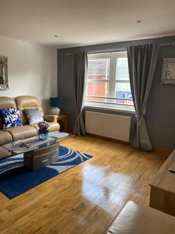 a living room with a couch and a window at Georges 1Faraline court Apartment in Inverness