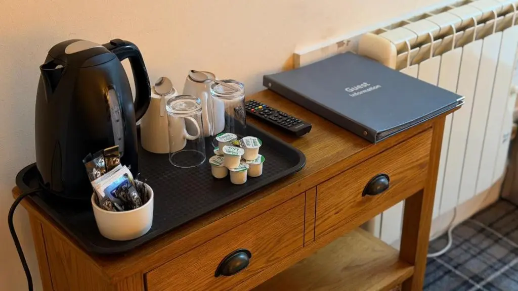 a table with a coffee maker and a laptop on it at The Waverley Guest House in Inverness