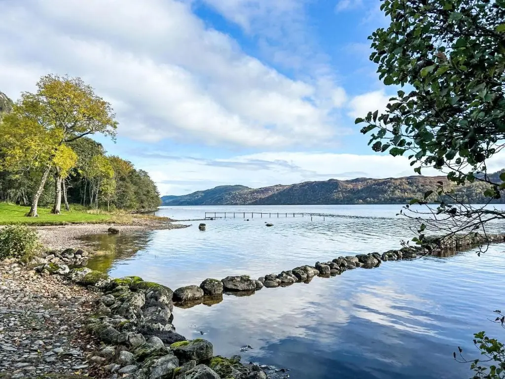 a view of a lake with rocks in the water at Holiday Home The Romantic Bothy by Interhome in Invermoriston