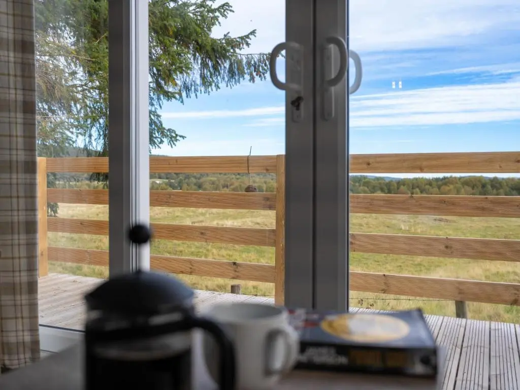 a window with a view of a wooden fence at Chalet Lodge 15 by Interhome in Boat of Garten