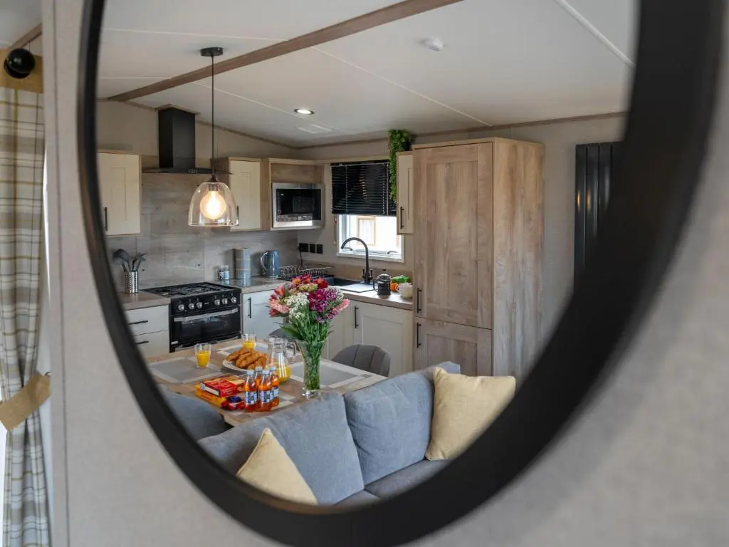 a view of a kitchen with a table in a mirror at Chalet Lodge 15 by Interhome in Boat of Garten