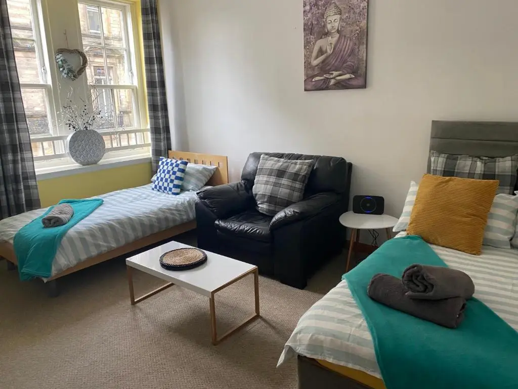 a living room with a couch and a chair at Church st 48B in Inverness