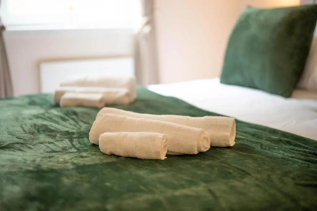 two rolled up towels sitting on top of a bed at Aberdeen 2BR Flat Near Airport & City Centre in Aberdeen