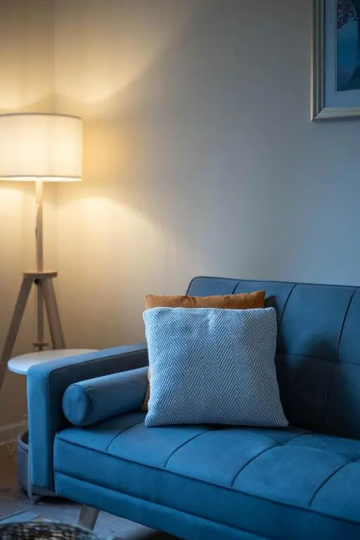 a blue couch in a living room with a lamp at Aberdeen 2BR Flat Near Airport & City Centre in Aberdeen