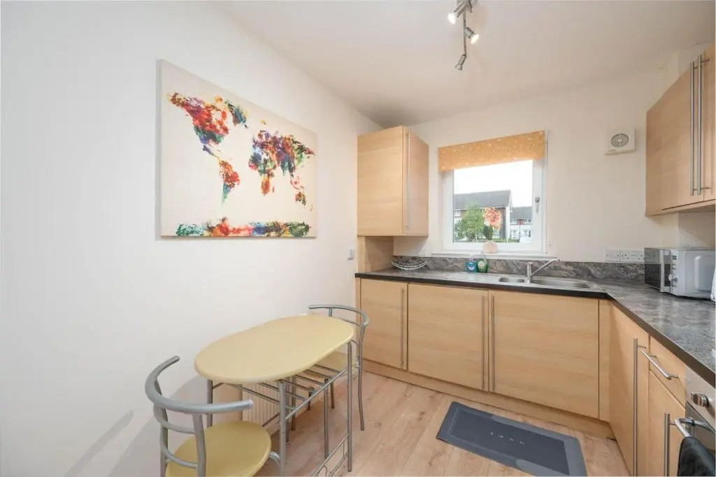 a kitchen with a table and two stools at Aberdeen 2BR Flat Near Airport & City Centre in Aberdeen