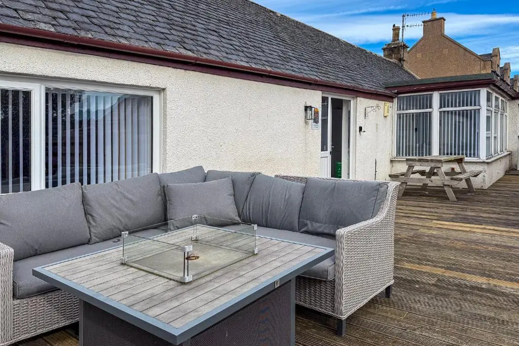 a patio with a couch and a table on a deck at Duffus Nights in Duffus