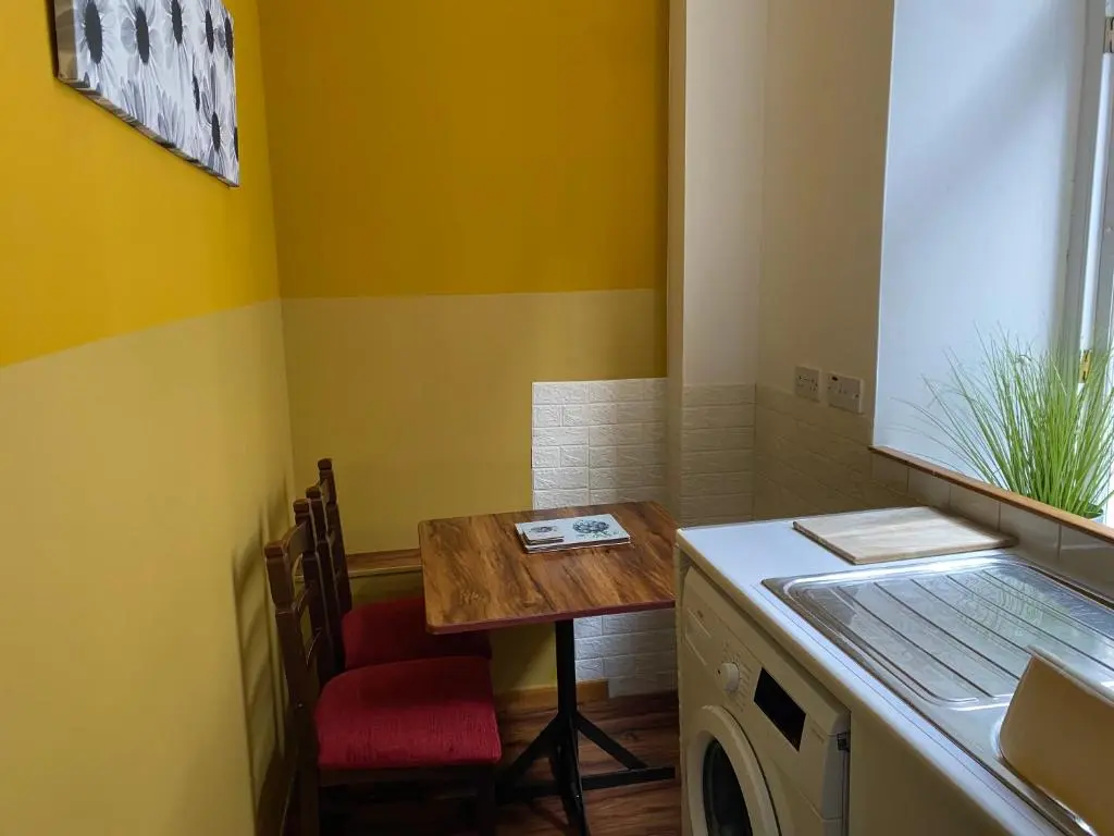a laundry room with a table and a washing machine at Lombard in Inverness