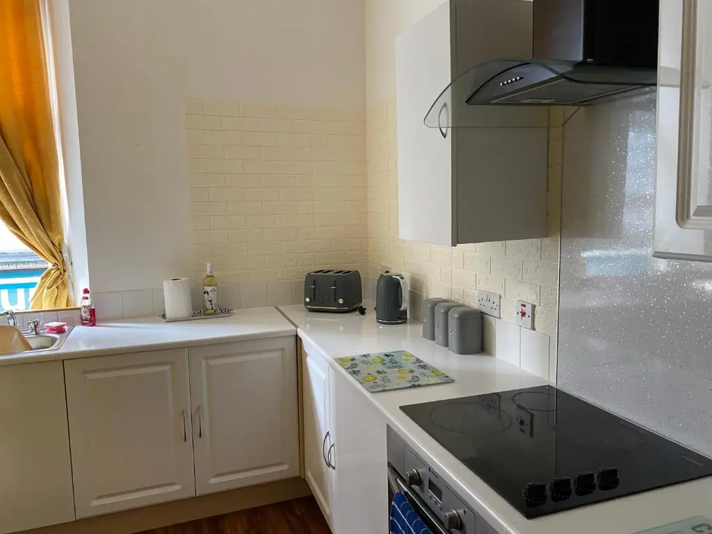 a kitchen with white cabinets and a stove top oven at Lombard in Inverness
