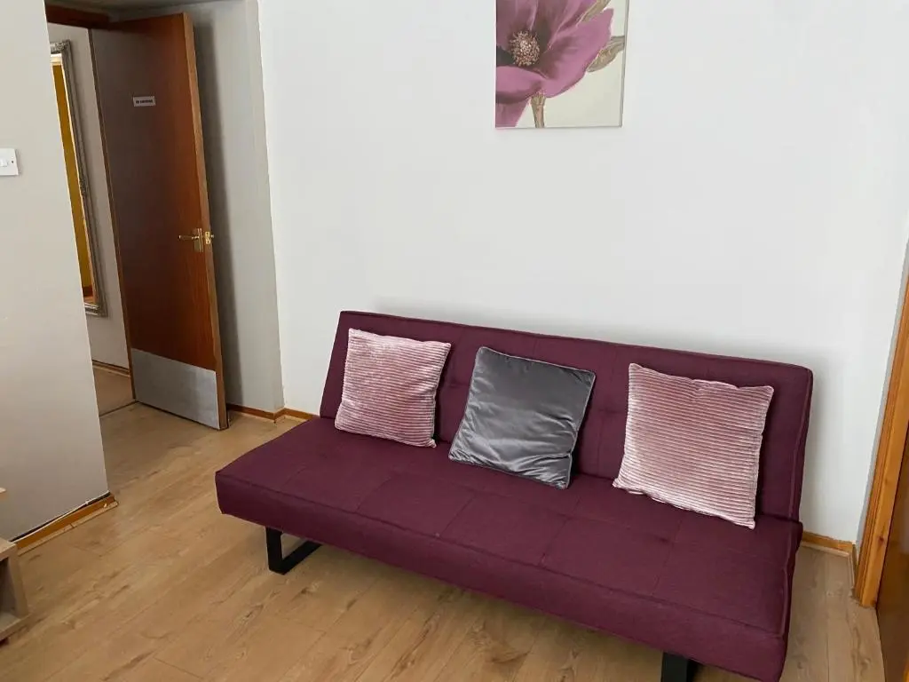 a purple couch in a living room with three pillows at Lombard in Inverness