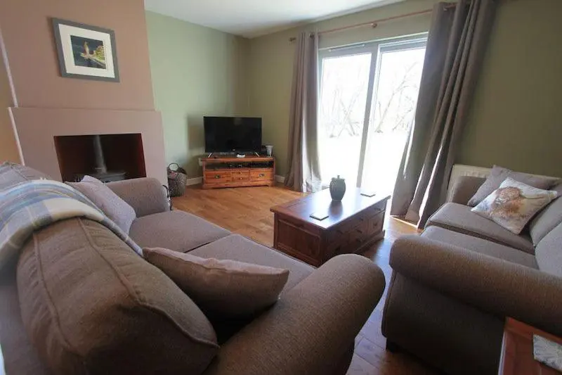 a living room with two couches and a television at Cottage 7 - Skye Cottage in Fort Augustus