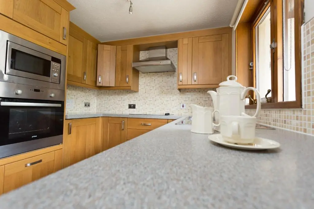 a kitchen with wooden cabinets and a tea kettle on a counter at Macdonald Spey Valley Resort in Aviemore