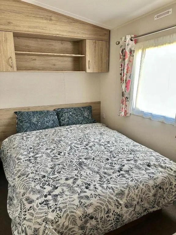 a bedroom with a bed with a blue and white comforter at Aurora Sky in Lossiemouth