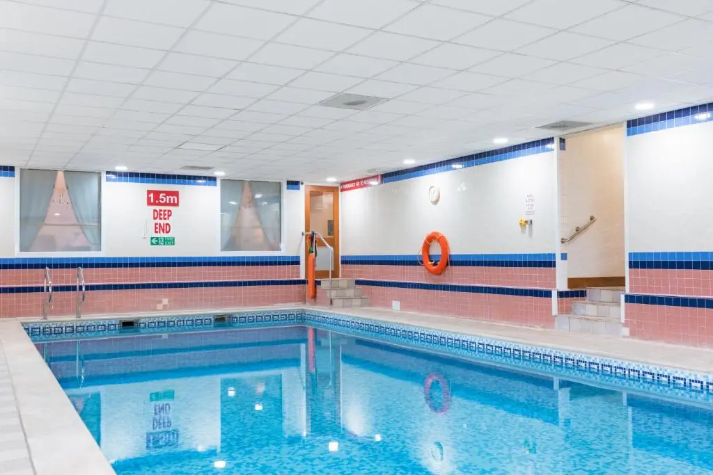 a large swimming pool in a gym with at Macdonald Lochanhully Resort in Aviemore