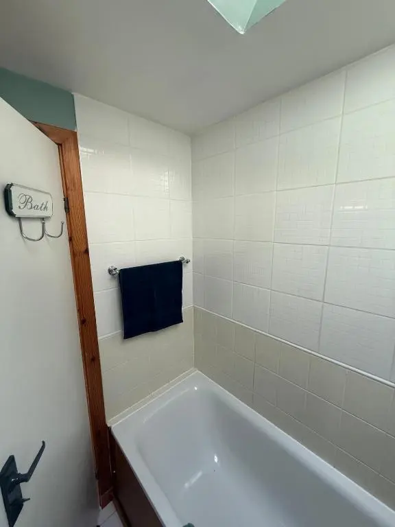 a bath tub in a bathroom with a blue towel at Friar's Rest - Beauly Village in Beauly