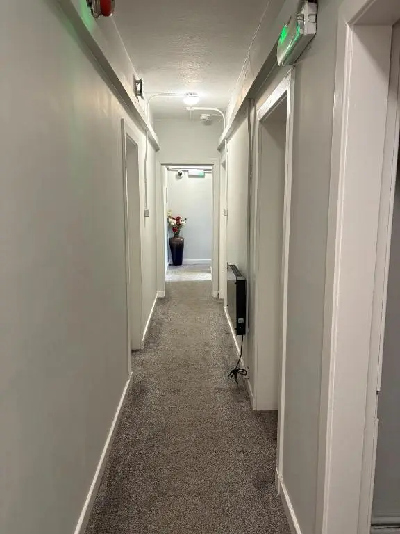 a corridor of a hallway with a room with a vase of flowers at Cannich at RHA in Dalneigh