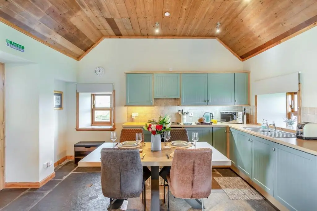 a kitchen with blue cabinets and a wooden ceiling at 1 Bed in Wick oc-b33442 in Wick